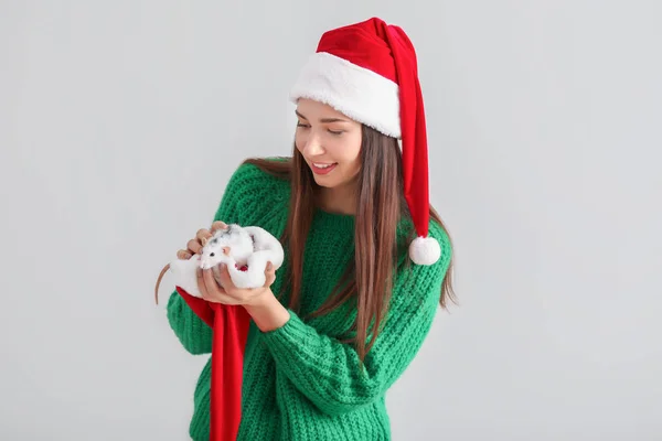 Молодая женщина с милой крысой в шляпе Санта-Клауса на белом фоне — стоковое фото