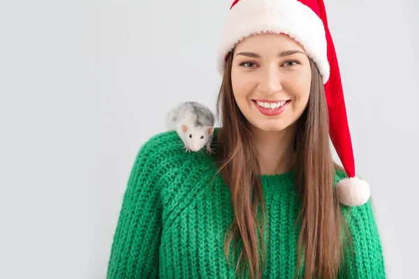 Jeune femme dans le chapeau du Père Noël et avec rat mignon sur fond blanc — Photo