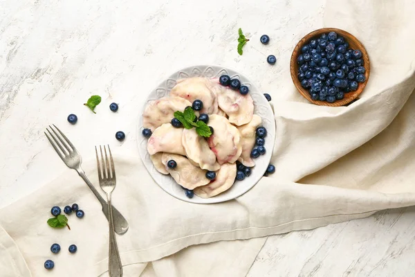 Plate with tasty dumplings and blueberry on table — Stock Photo, Image