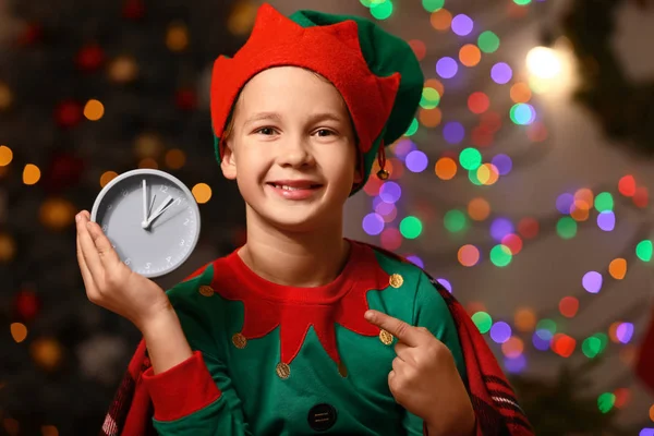 Little boy in costume of elf and with clock in room decorated for Christmas — Stock Photo, Image