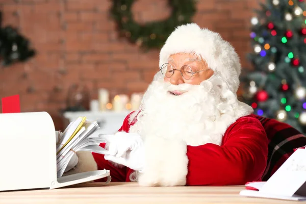 Kerstman met brieven in de kamer versierd voor Kerstmis — Stockfoto