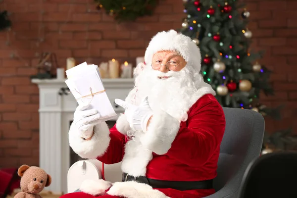 Kerstman met brieven in de kamer versierd voor Kerstmis — Stockfoto