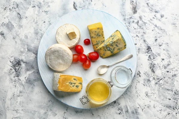 Plateau avec assortiment de fromages frais et miel sur fond blanc — Photo