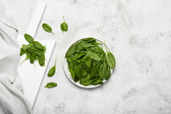 Plate with fresh spinach on light background — Stock Photo, Image