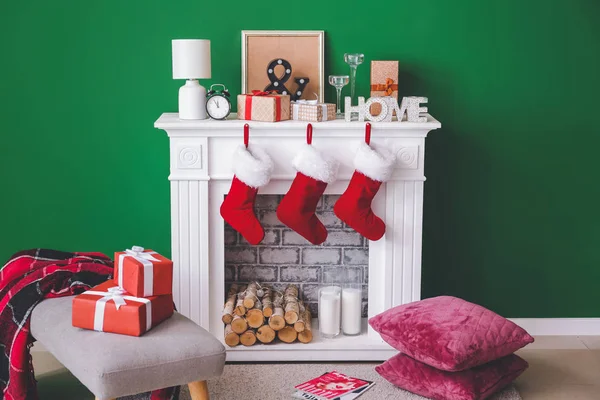 Christmas socks with gifts hanging on fireplace in interior of room — Stock Photo, Image