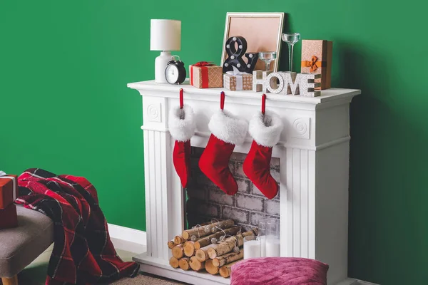 Christmas socks with gifts hanging on fireplace in interior of room — Stock Photo, Image