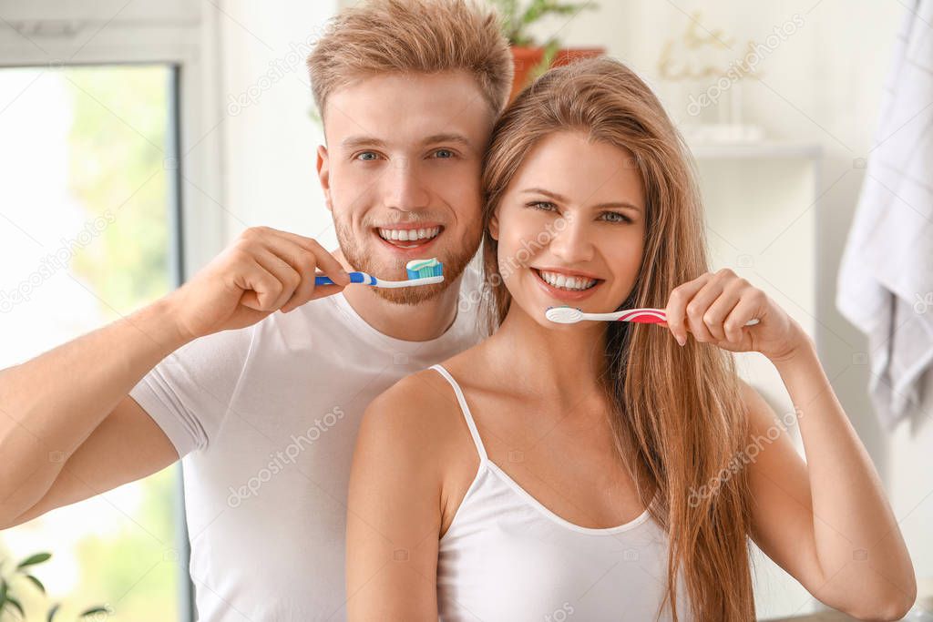 Young couple brushing teeth at home
