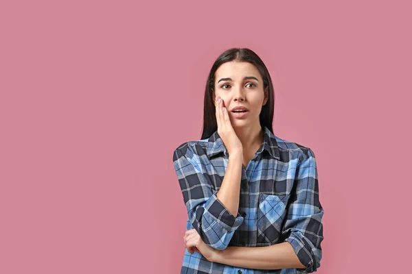 Porträt einer besorgten jungen Frau auf farbigem Hintergrund — Stockfoto