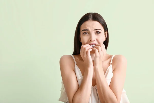 Retrato de mujer joven preocupada sobre fondo de color —  Fotos de Stock