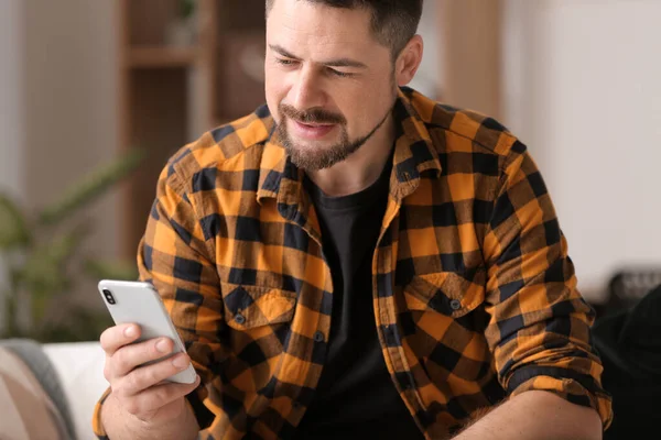 Mature man with mobile phone at home — Stock Photo, Image