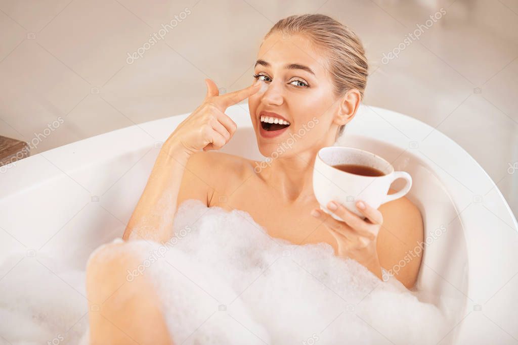 Happy young woman relaxing in bathroom