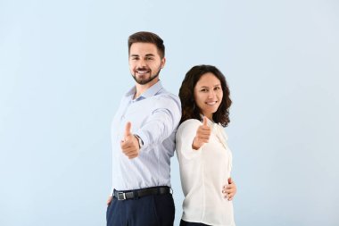 Genç iş adamlarının portresi renk arka planında başparmak hareketi gösteriyor