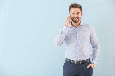 Arka planda cep telefonuyla konuşan genç işadamının portresi