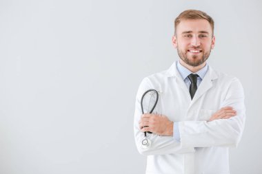 Açık arkaplanda steteskobu olan erkek doktorun portresi