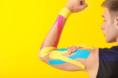 Kolunda renk arkaplanı olan spor bandı olan bir adam