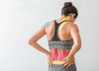 Fizyolojik bandı olan sportif bir kadın arka planda hafif arkaplana uygulanmış.