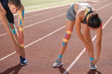 Stadyumda fizyoteyp eğitimi almış sportif bir çift.
