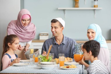 Müslüman bir aile evde yemek yiyor.