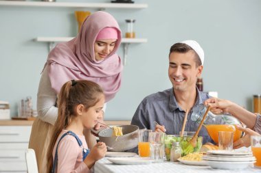 Müslüman bir aile evde yemek yiyor.