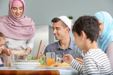 Müslüman bir aile evde yemek yiyor.
