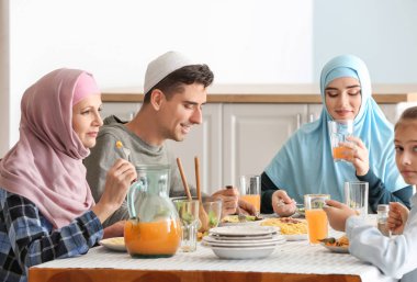 Müslüman bir aile evde yemek yiyor.