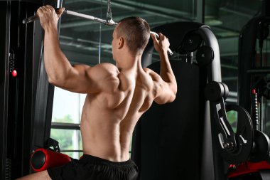 Sportif kaslı adam spor salonunda çalışıyor.