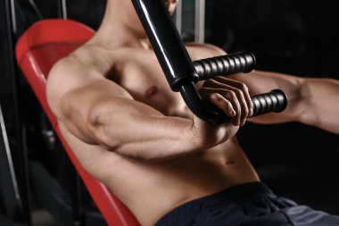 Sportif kaslı adam spor salonunda çalışıyor.