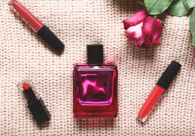 Bir şişe parfüm ve makyaj malzemesi örülmüş kazak.