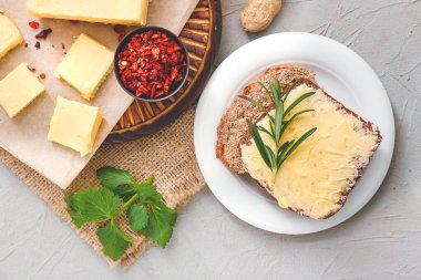 Baharatlı lezzetli tereyağı ve gri arka planda ekmek.