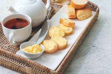 Masada lezzetli ekmek, tereyağı ve çay tepsisi