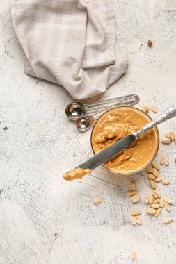 Beyaz arka planda fıstık ezmeli ve bıçaklı kase.