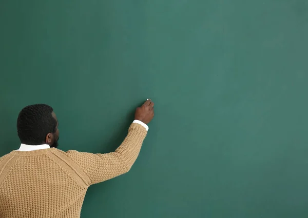 Profesora afroamericana escribiendo en pizarra en clase — Foto de Stock