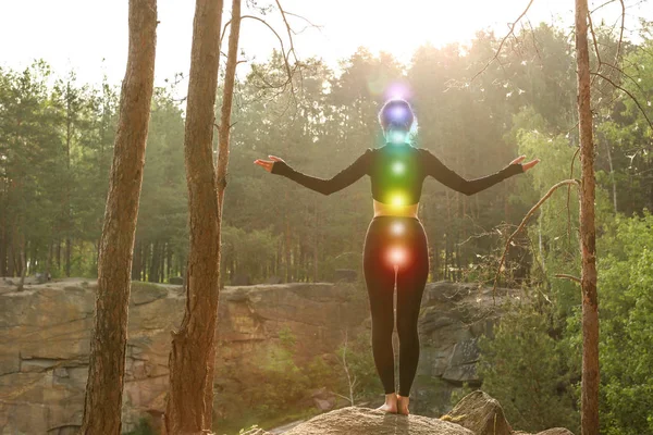 Mujer con chakras coloridos meditando en el bosque —  Fotos de Stock