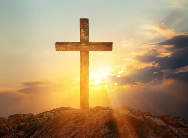 Скала с христианским крестом на закате — стоковое фото