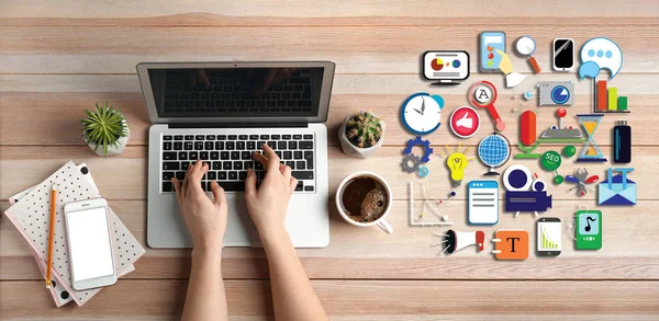 Businesswoman with laptop and digital icons sitting at workplace, top view — Stock Photo, Image