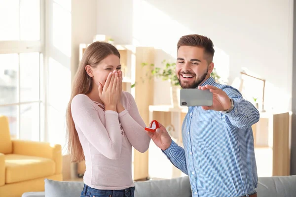 Young man taking selfie while proposing to his beloved at home — Stock Photo, Image