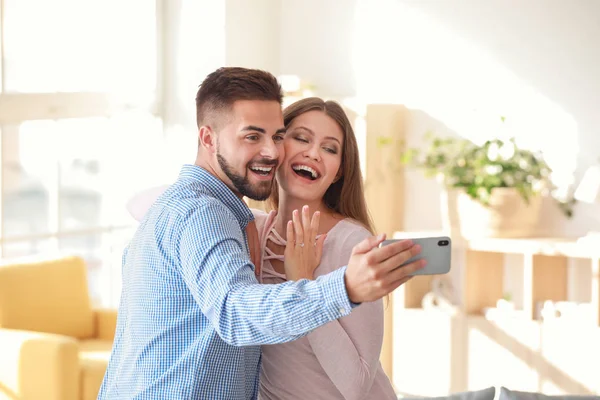Ευτυχισμένο αρραβωνιασμένο ζευγάρι που βγάζει selfie στο σπίτι — Φωτογραφία Αρχείου