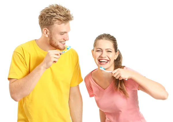 Giovane coppia lavarsi i denti su sfondo bianco — Foto Stock