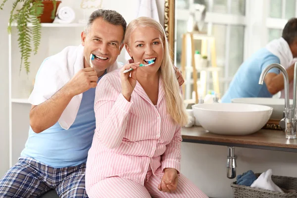 Mature couple brushing teeth at home — Stock Photo, Image