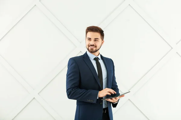 Retrato de empresário bonito com computador tablet em fundo cinza — Fotografia de Stock