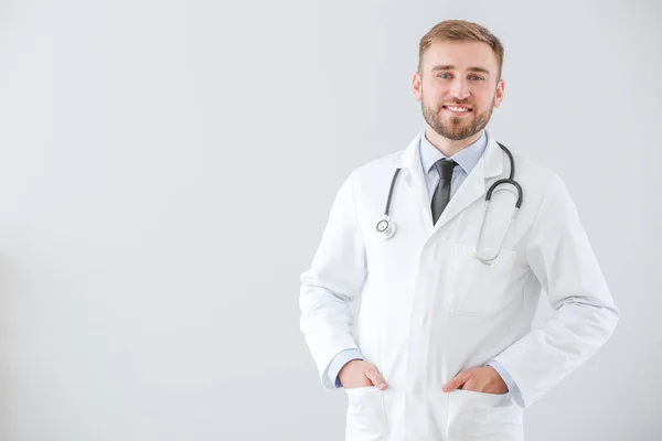 Portrait of male doctor on light background — Stockfoto
