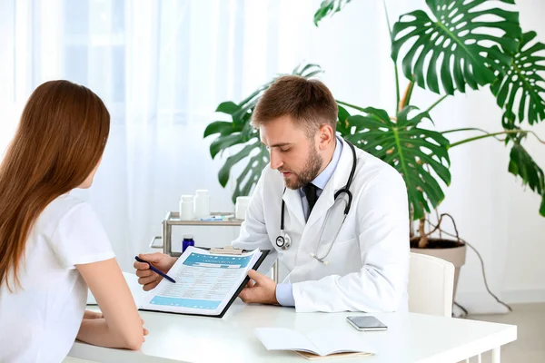 Male doctor working with female patient in clinic — Stock Photo, Image