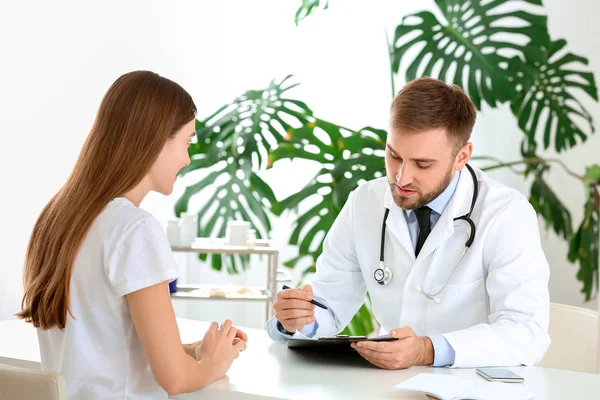 Male doctor working with female patient in clinic — Stock Photo, Image