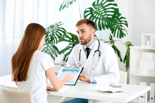 Male doctor working with female patient in clinic — Stock Photo, Image