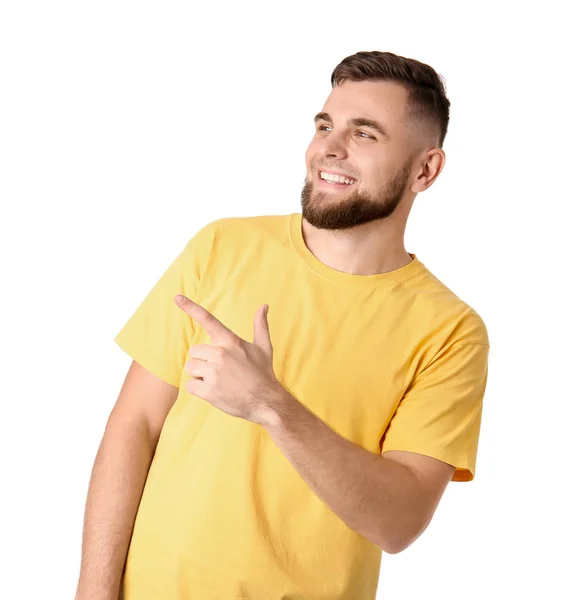 Handsome young man pointing at something on white background — Stock Photo, Image