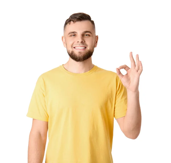 Przystojny młody człowiek pokazuje OK gest na białym tle — Zdjęcie stockowe