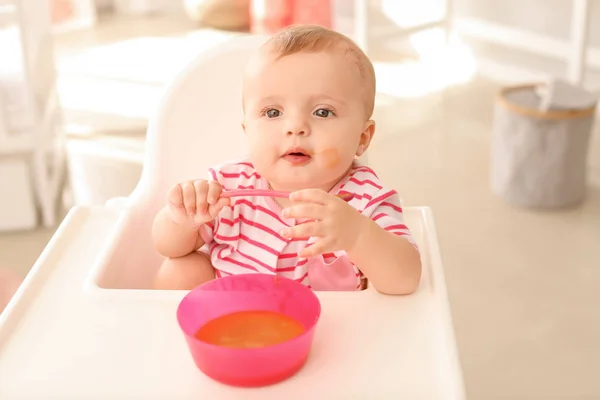 Retrato de bebé lindo comiendo comida sabrosa en la cocina — Foto de Stock