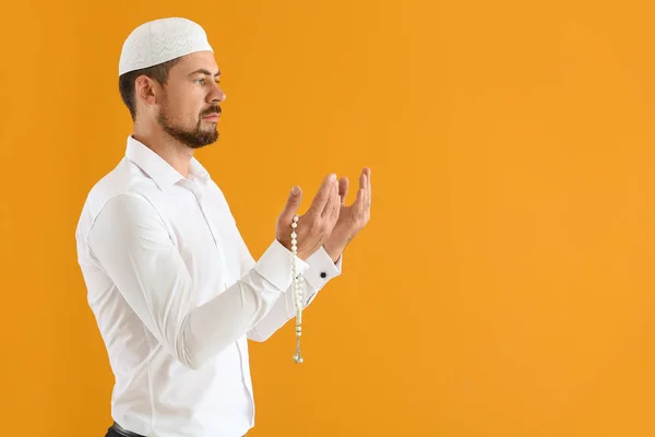 Uomo musulmano che prega contro lo sfondo di colore — Foto Stock