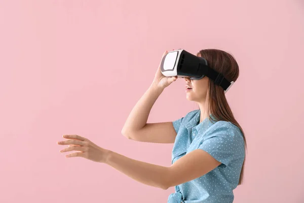 Młoda kobieta w okularach wirtualnej rzeczywistości na tle koloru — Zdjęcie stockowe