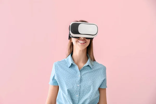Młoda kobieta w okularach wirtualnej rzeczywistości na tle koloru — Zdjęcie stockowe